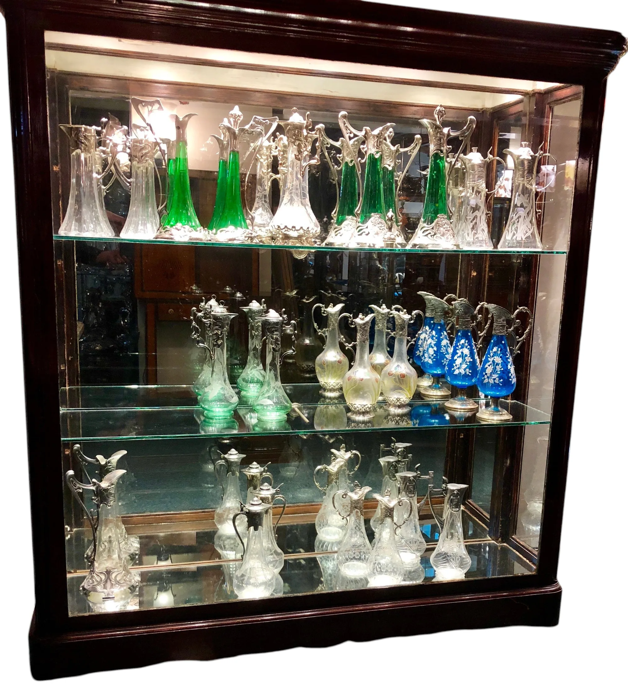 Deux pichets anciens WMF décorés exposés dans une vitrine