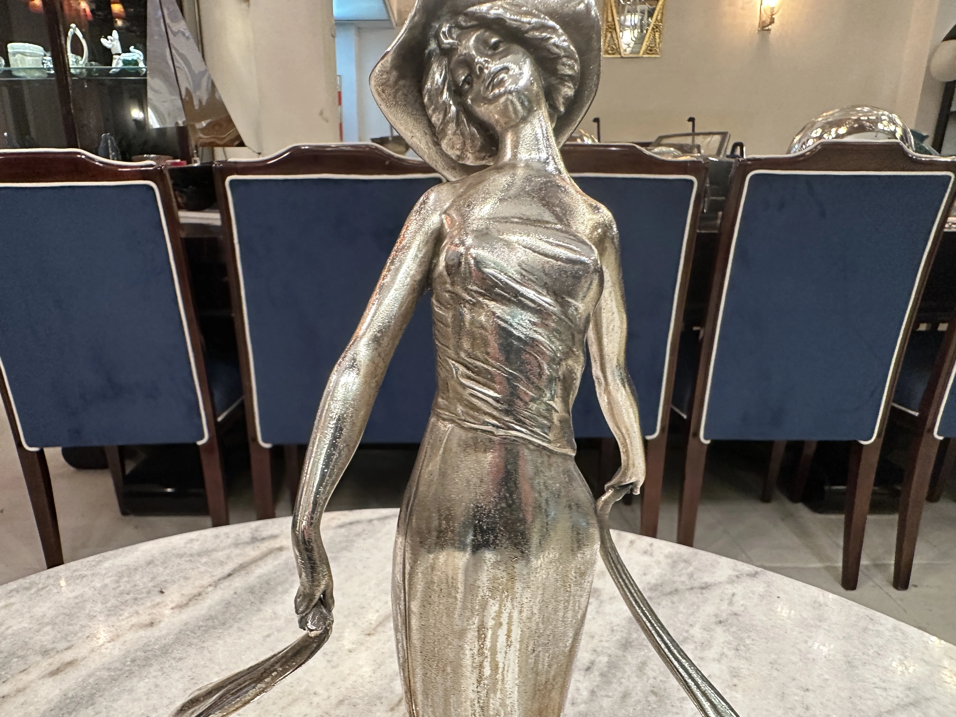 Статуя женщины в шляпе в элегантной обстановке.