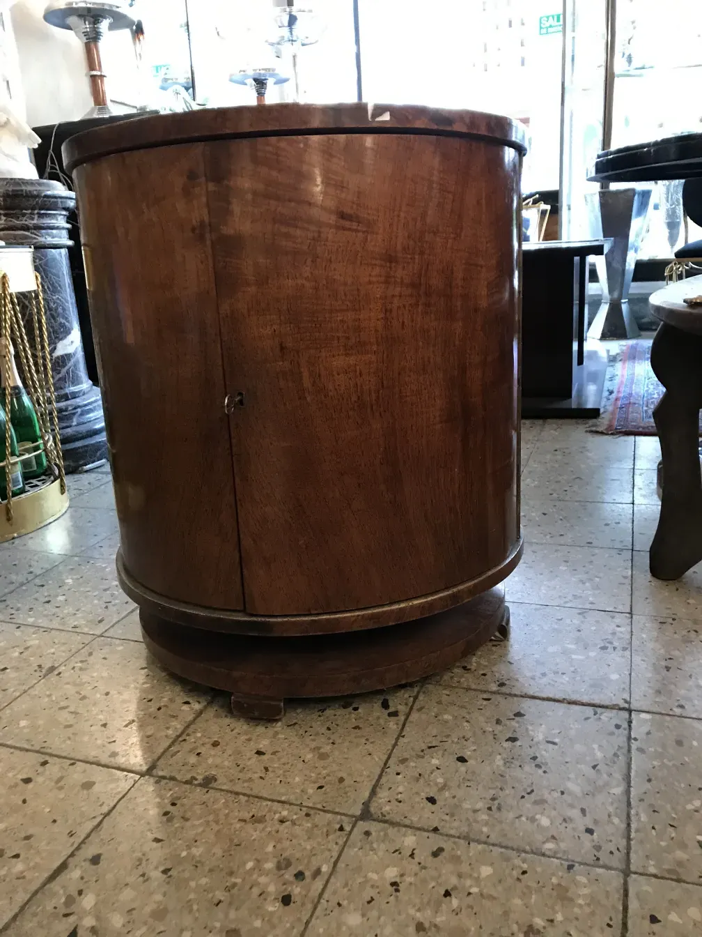 Antique wooden bar cabinet, elegant and curved, in a store