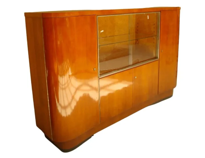 Mueble bar antiguo con detalles curvados y vitrinas.