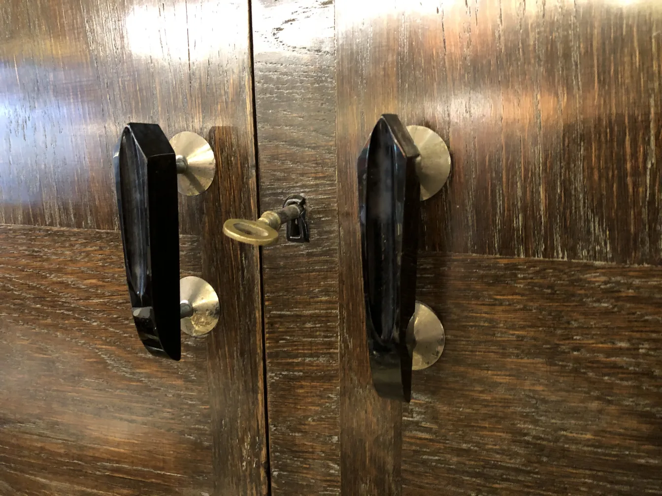 Mobile bar antico con finitura in legno e dettagli in metallo.