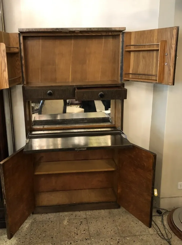 Meuble à cocktail ancien avec miroir, étagères et design élégant.