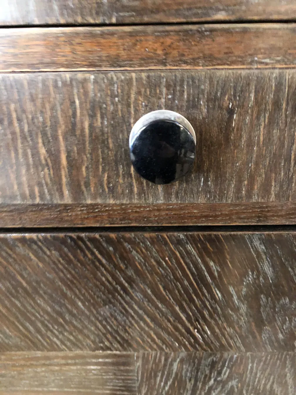 détail d'un meuble à cocktail ancien avec une poignée ronde noire