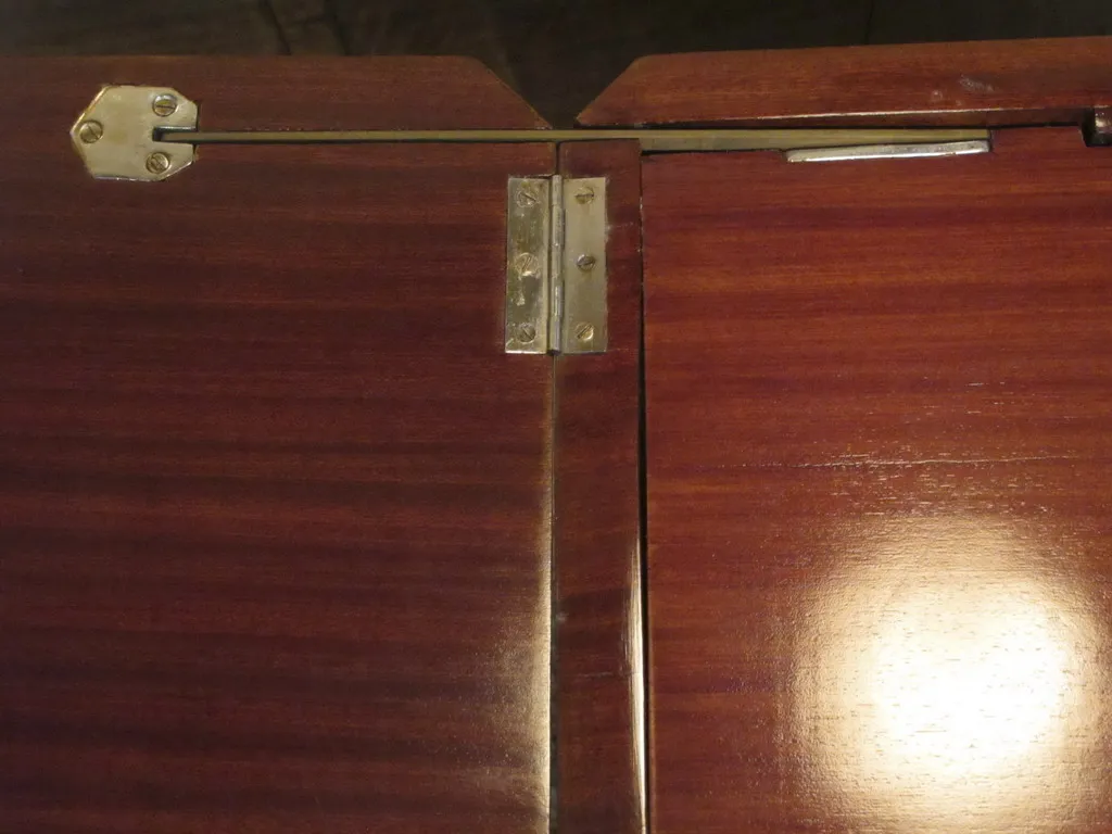 Detalle de un mueble bar antiguo con herrajes metálicos.