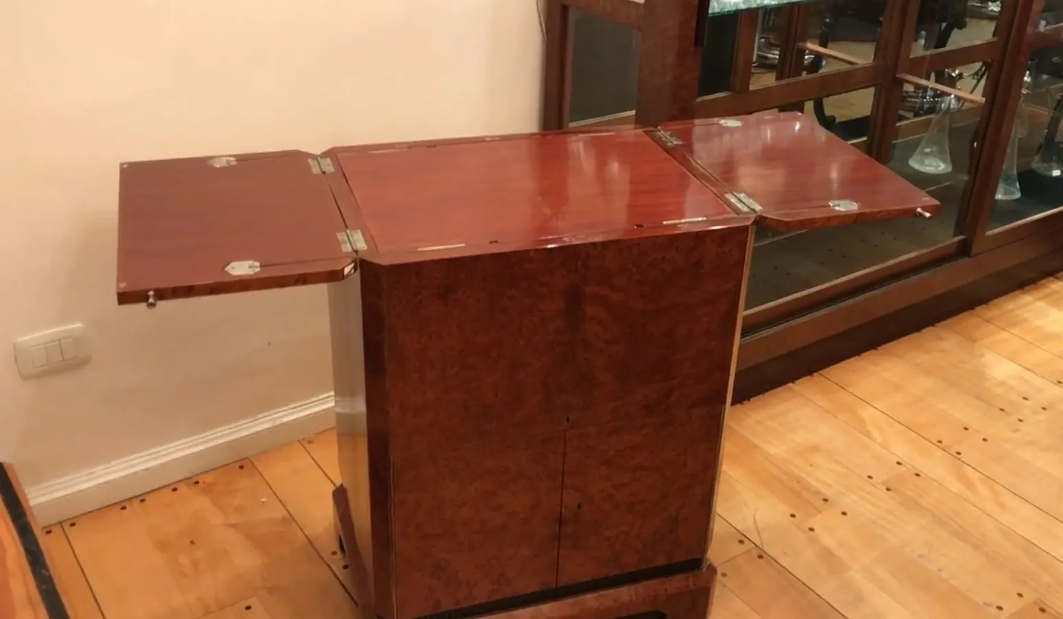 Meuble à cocktail ancien en bois avec espace pour bouteilles.