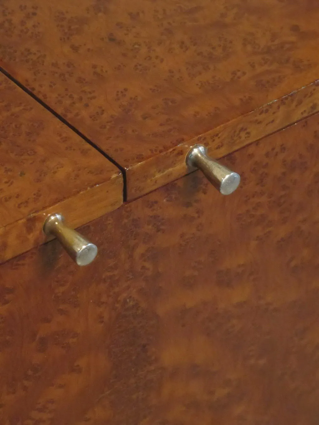 Close-up of an antique bar cabinet with metal handles