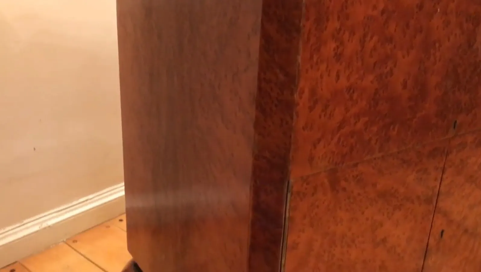 Antiker Cocktailschrank aus Holz mit glänzender Oberfläche und eleganten Details in einem gemütlichen Ambiente.