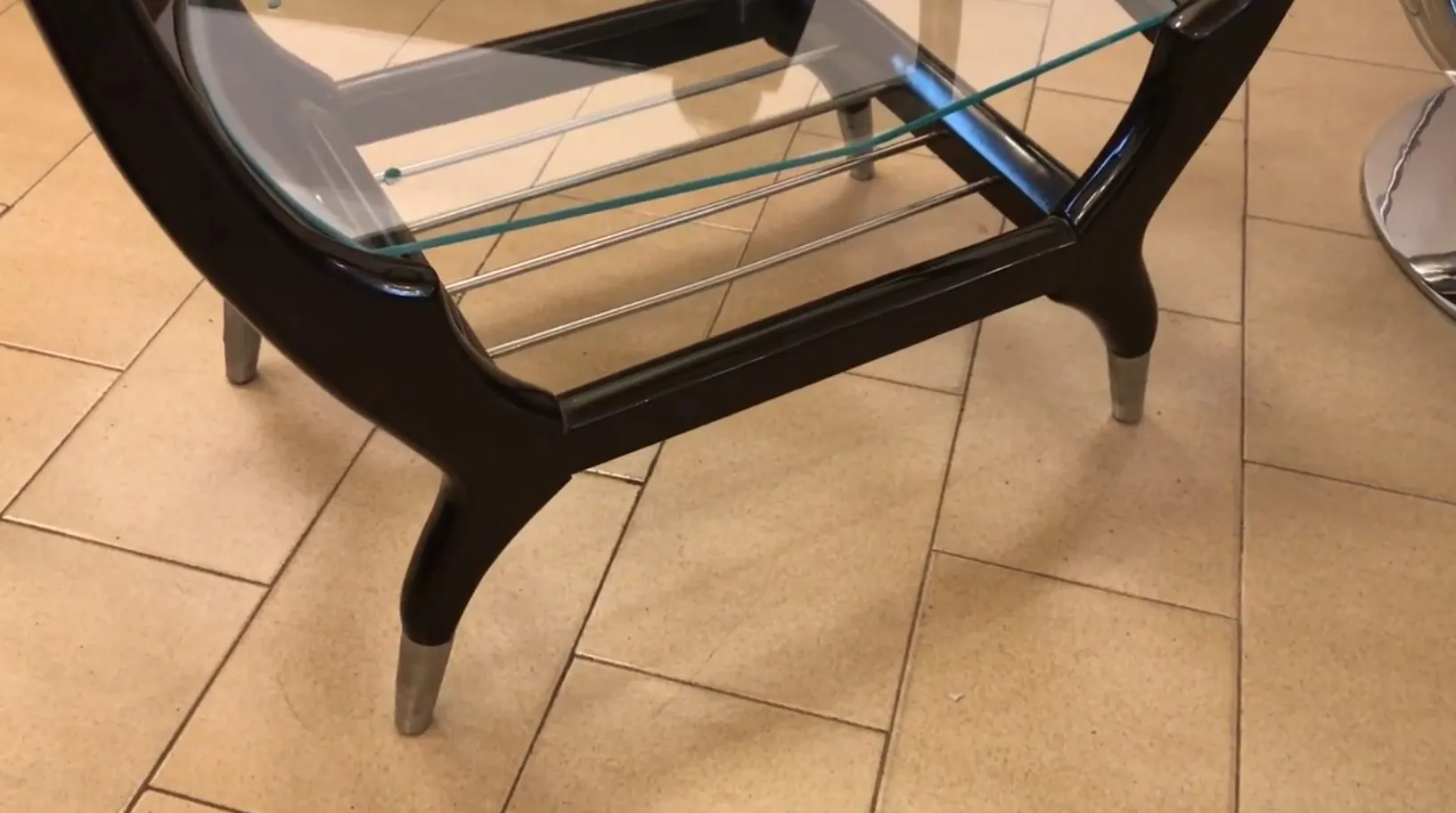 Mueble bar antiguo con superficie de cristal y patas estilizadas