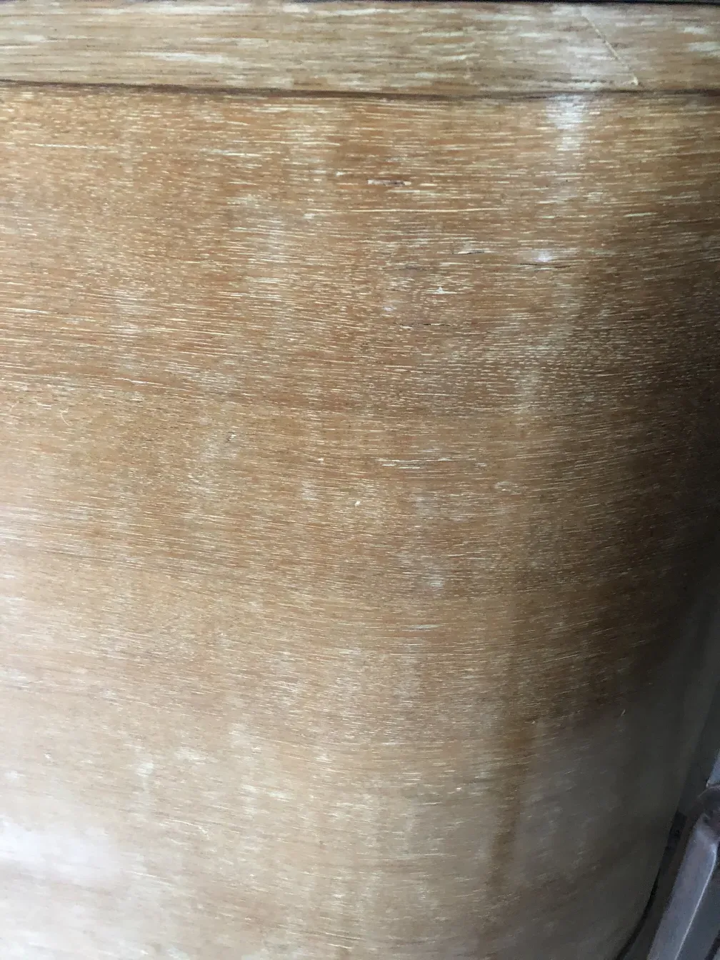 Mueble bar antiguo con acabado en madera clara en ambiente rústico.