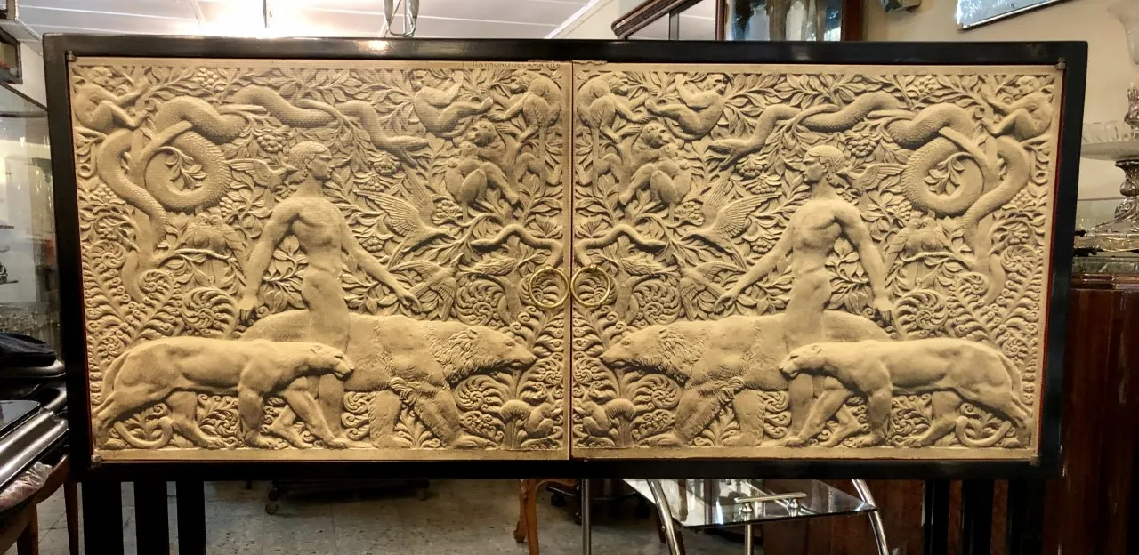 antique bookcase with human and animal relief figures, sculptural detail