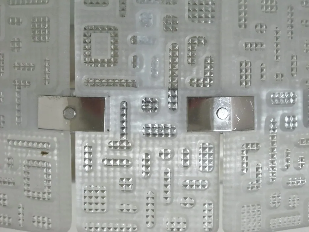 Coppia di applique antiche con un design geometrico e stilizzato, ideale per la decorazione.