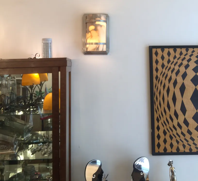 Par de luminárias de parede antigas com design elegante, iluminando uma atmosfera acolhedora ao lado de uma vitrine.