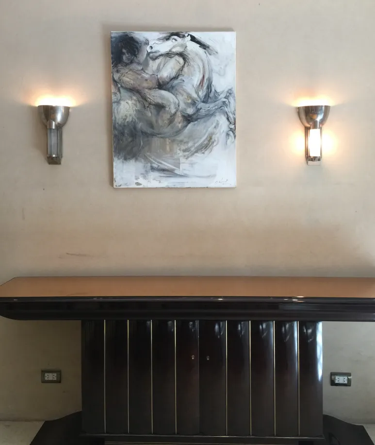 Paire d'appliques anciennes diffusant une douce lumière à côté d'une peinture