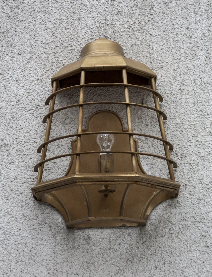 दीवार पर स्थापित प्राचीन सुनहरी स्कोनस, स्टाइलिश सजावट।