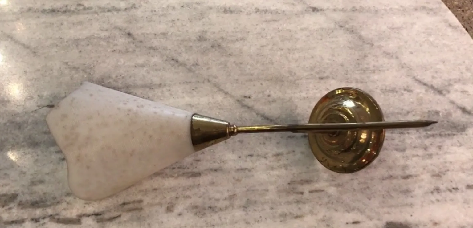 Coppia di applique antiche con base dorata e schermo in marmo, su sfondo di marmo chiaro.