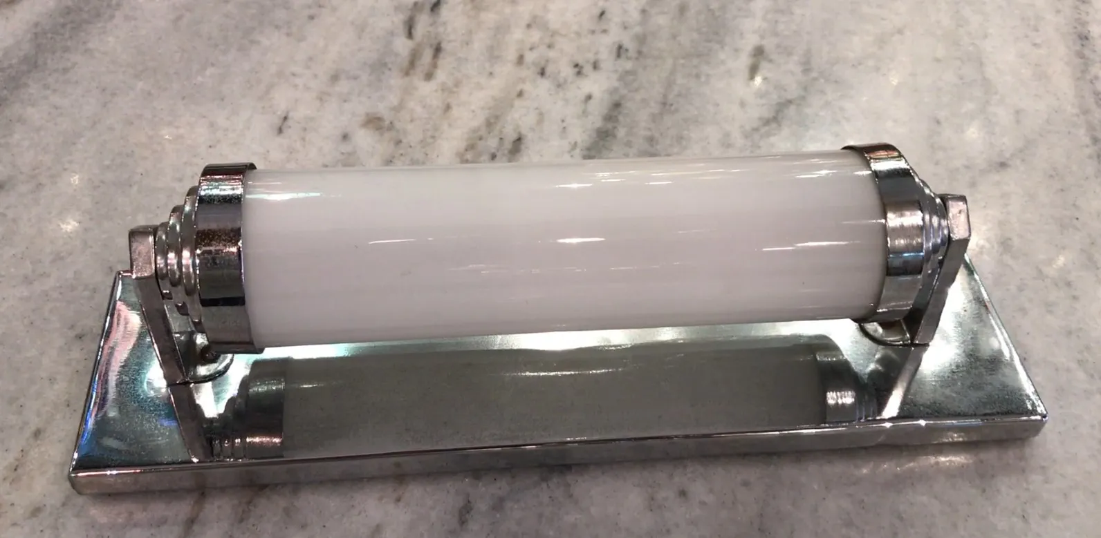 Par de luminárias de parede antigas com luz branca, estilo clássico, sobre superfície clara.