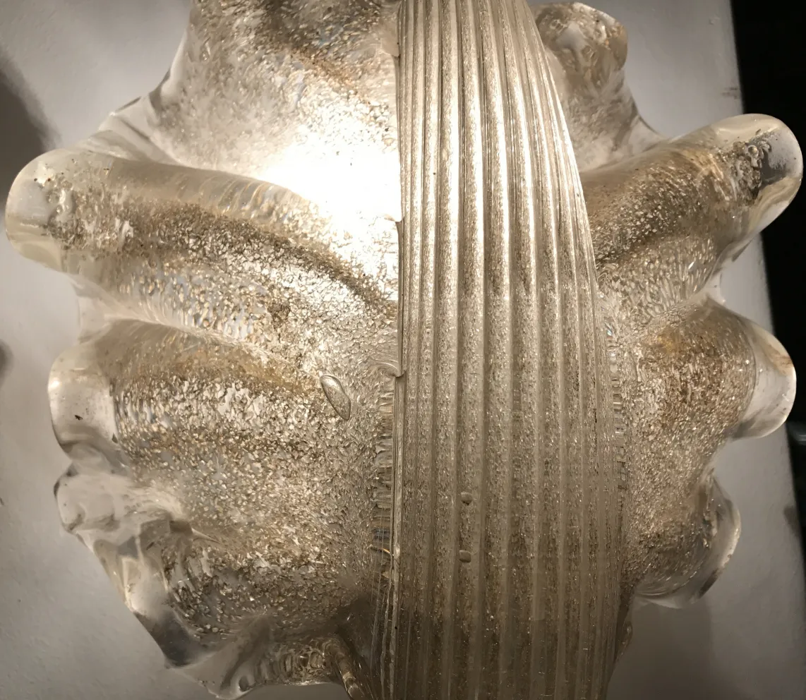 Antique pair of sconces with decorative shape and shiny texture.