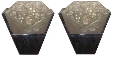 Par de apliques antiguos con diseño estilizado y relieve, en un ambiente acogedor.