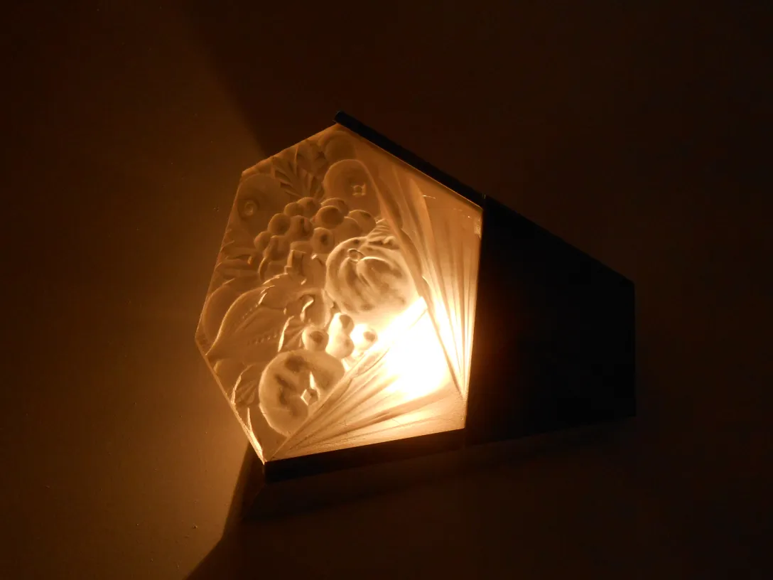 Coppia di applique antiche con rilievi decorativi e luce calda