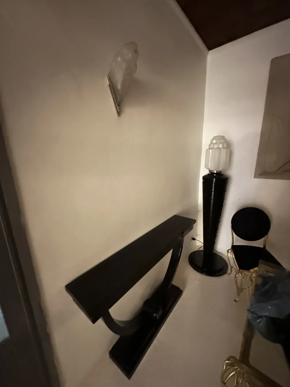 Par de luminárias de parede antigas com formato elegante, em fundo neutro.