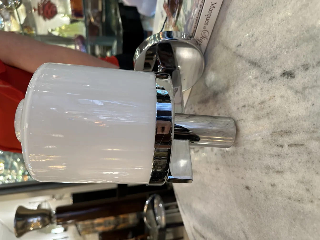 Coppia di applique antiche con design elegante e lucido. Viste su una superficie di marmo.