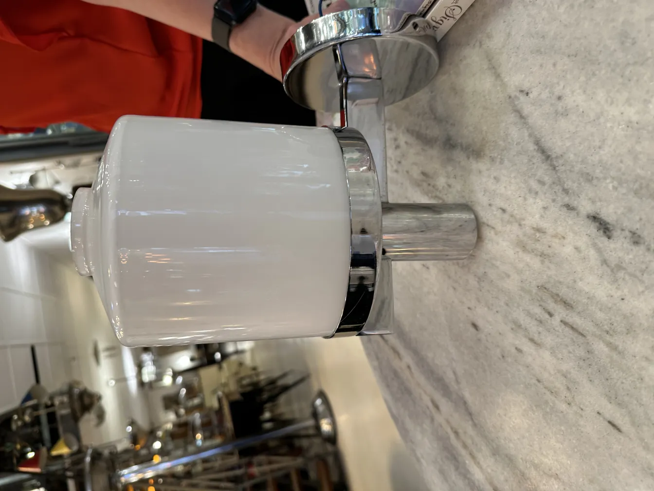 Par de apliques antiguos con base metálica brillante y pantalla de cerámica blanca, en un ambiente de estilo clásico.