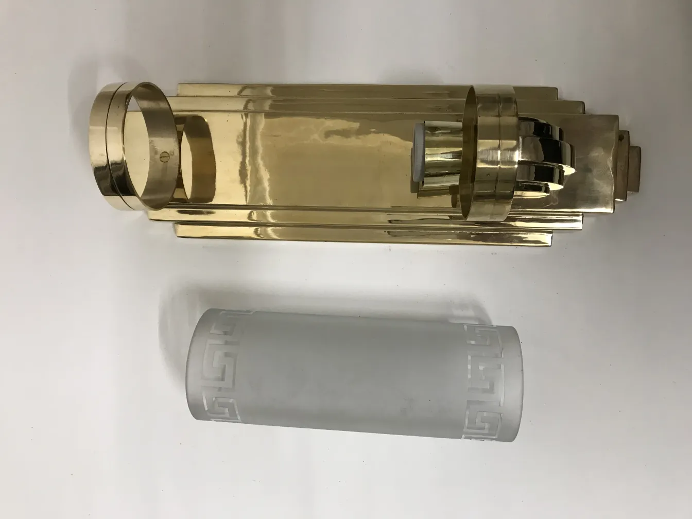 古董壁灯，拥有优雅的几何设计，一个是光亮的金色，另一个是玻璃扩散器。营造温暖的氛围。