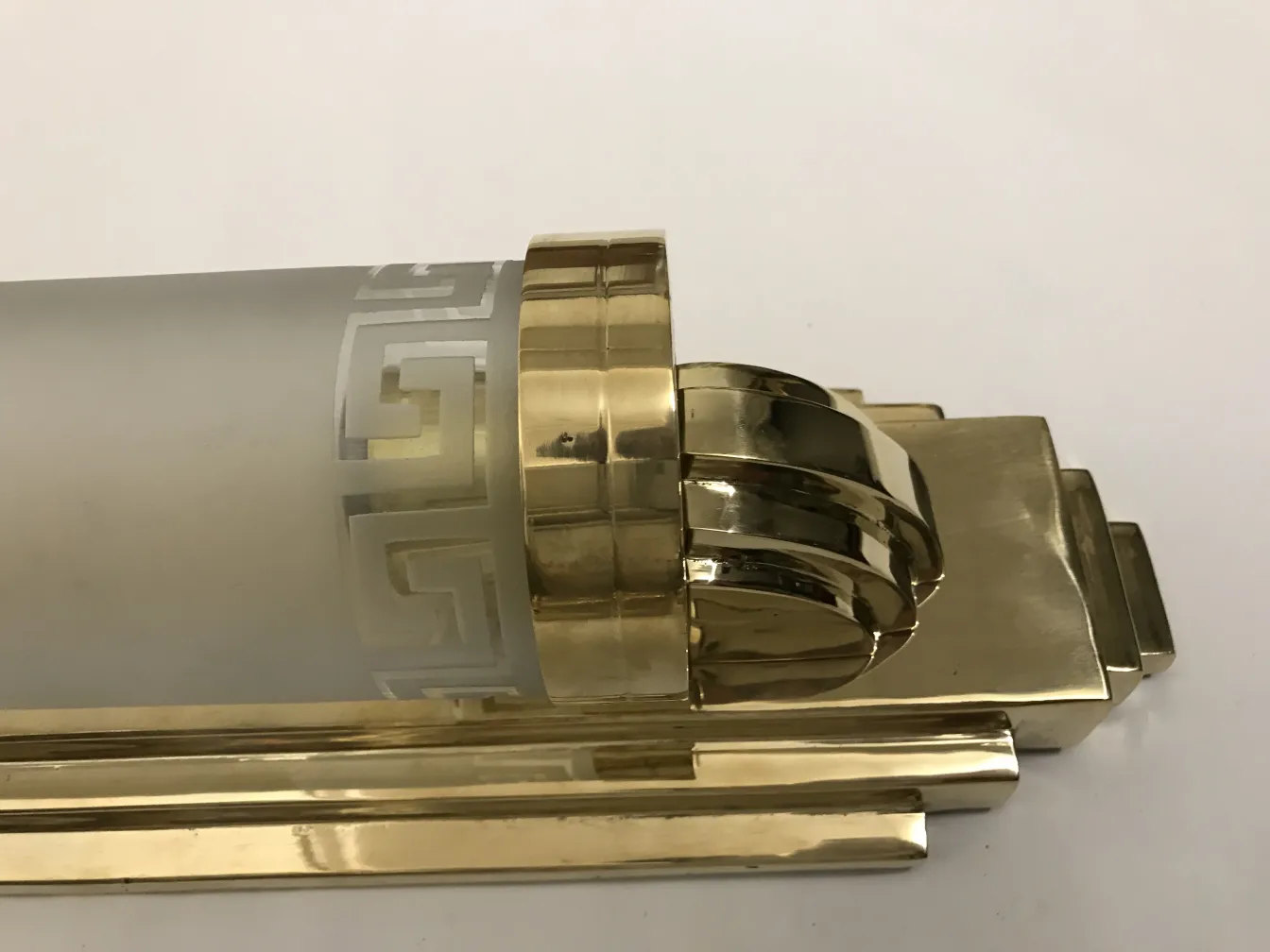 पुराने स्कोनस जो सोने की बुनाई से सजाए गए हैं, माहौल को बढ़ाते हैं