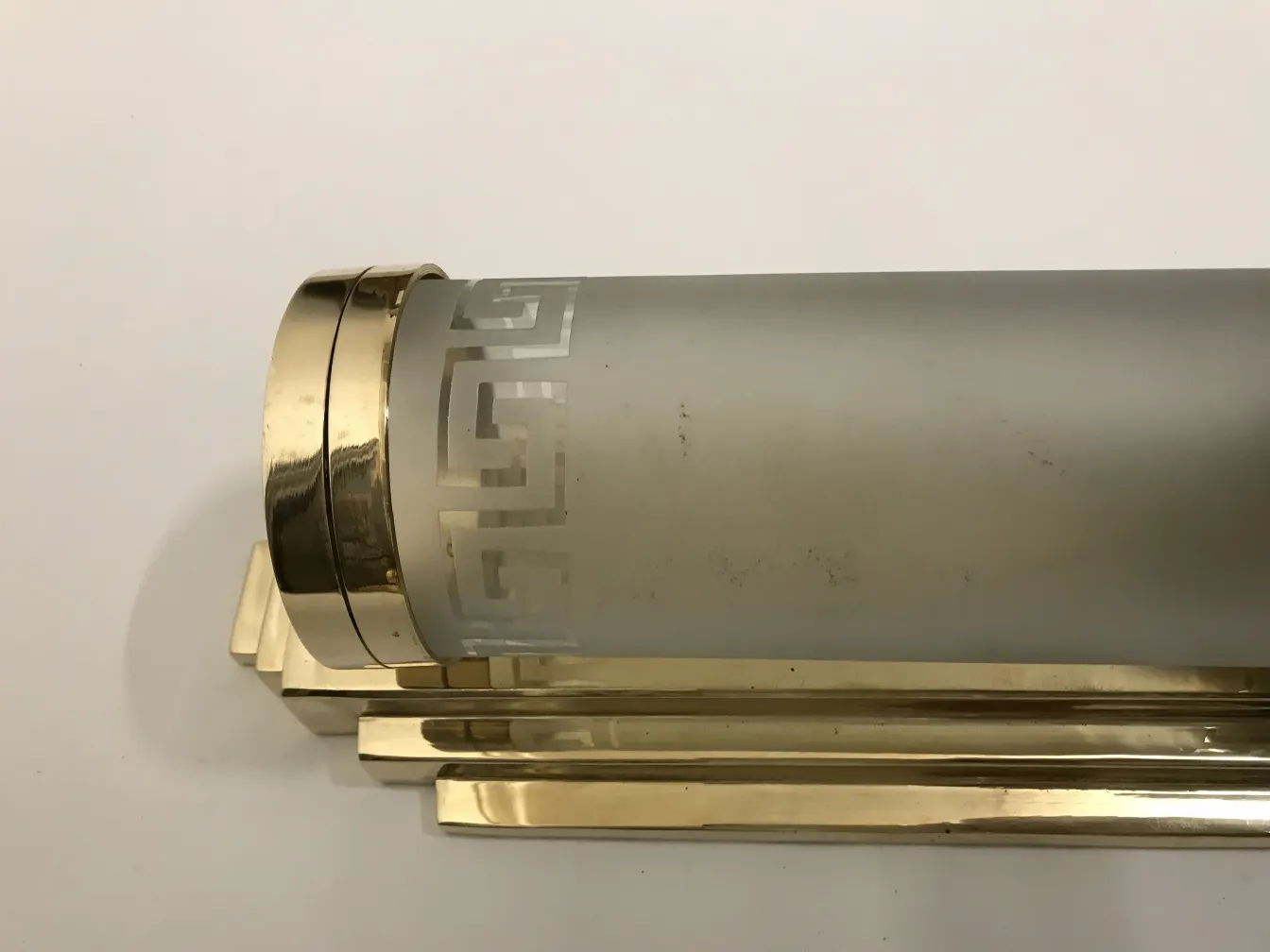 Par de luminárias de parede antigas com vidro fosco e base dourada.