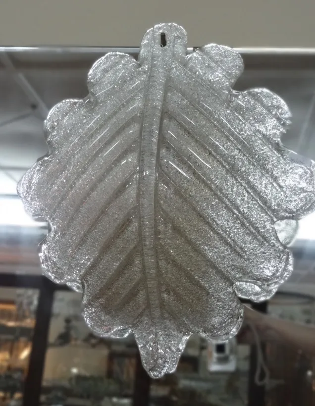 Coppia di applique antiche a forma di foglia, con delicati riflessi in un ambiente vintage.