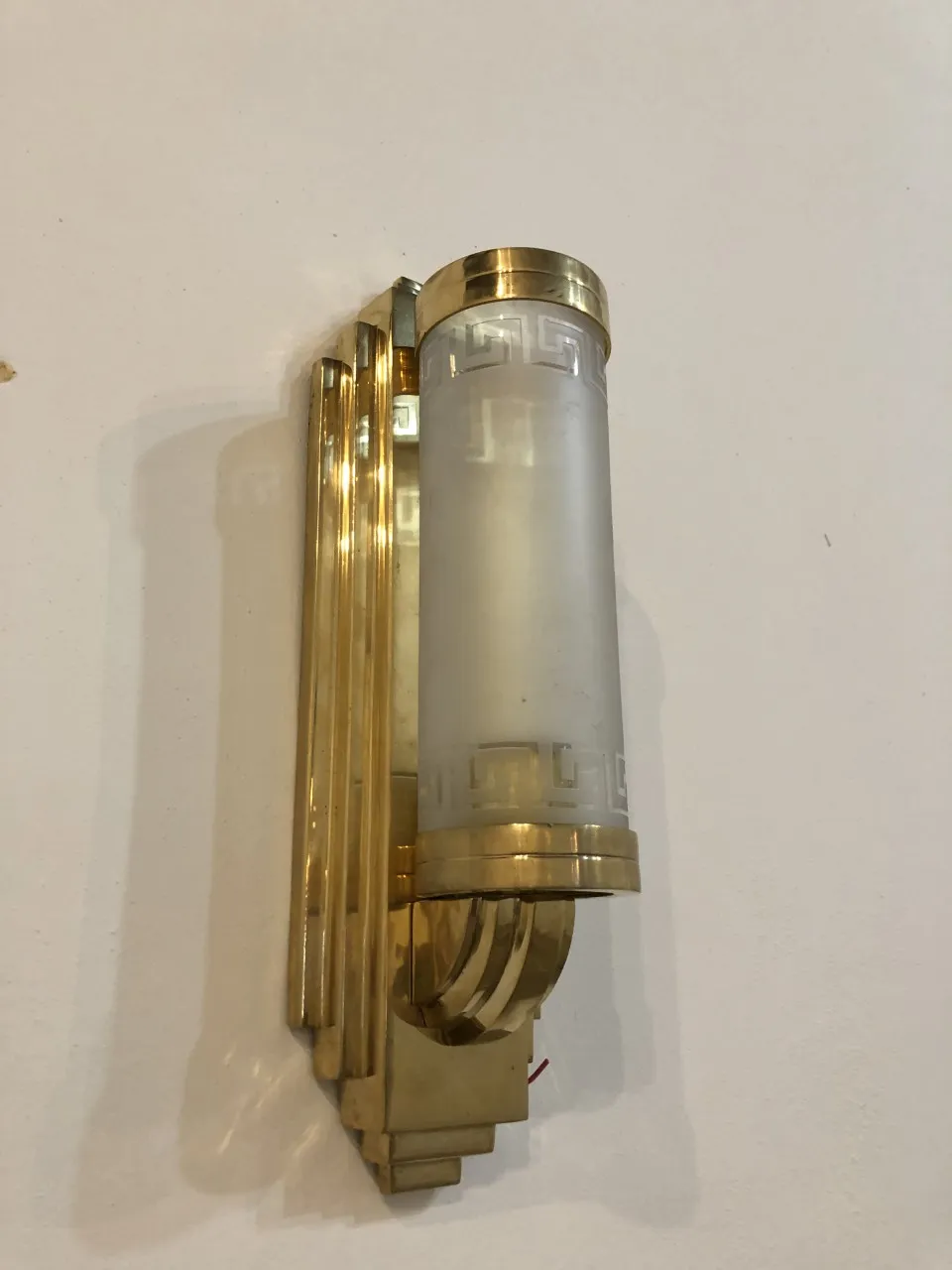 Elegante applique antica con vetro bianco opaco.