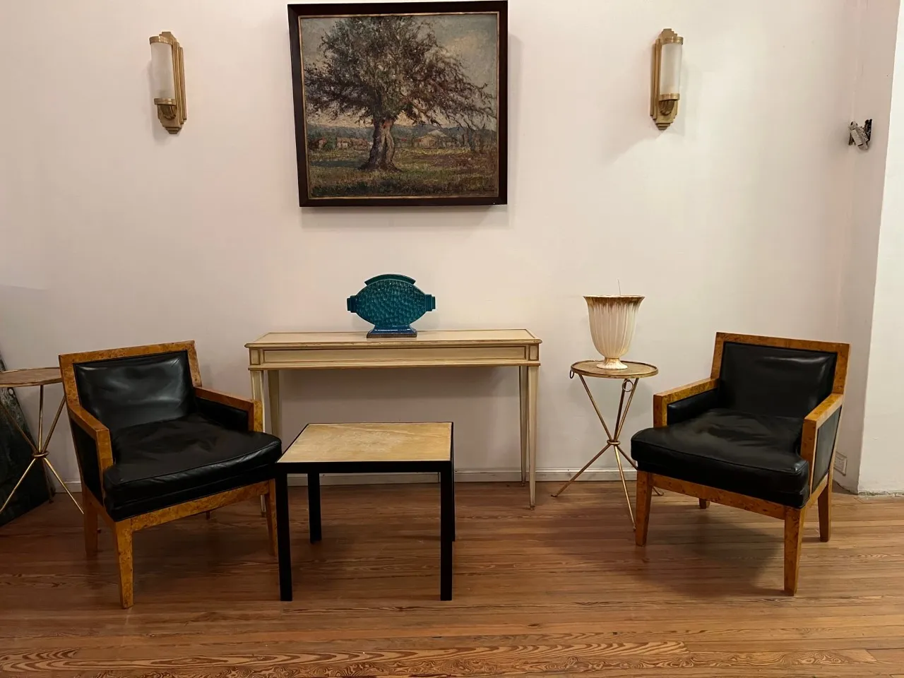 Par de apliques antiguos con luz suave y diseño clásico, decorando un ambiente acogedor con sillones y mesa.