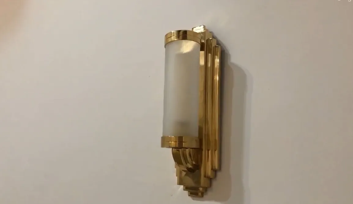 Elegante par de apliques dorados en la pared con luz suave.