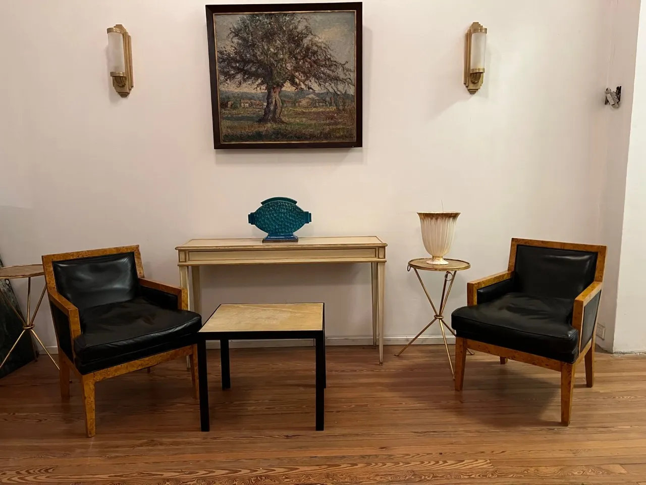 Paar antike Wandleuchten in einem eleganten Wohnzimmer mit Ledersesseln