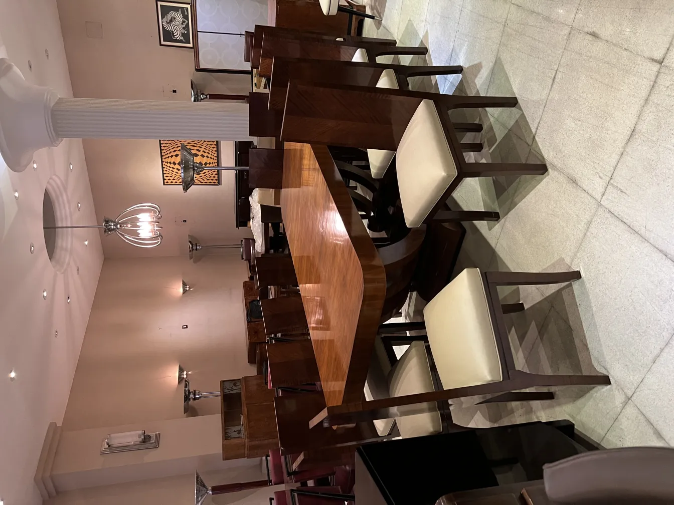 Apliques antigos em ambiente elegante com mesas e cadeiras.