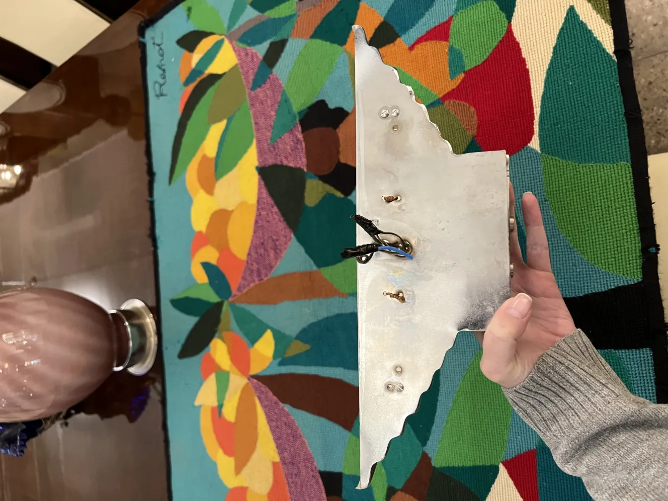 Un par de apliques antiguos, de diseño único, en una mesa colorida.