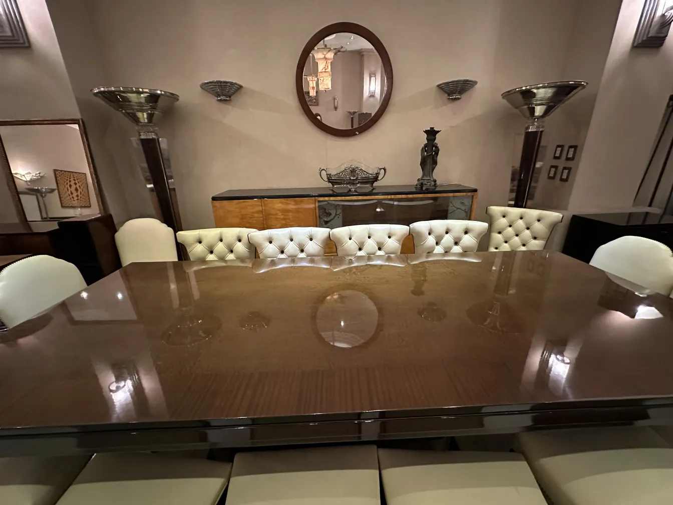 Coppia di applique antiche in un ambiente elegante con tavolo e sedie.