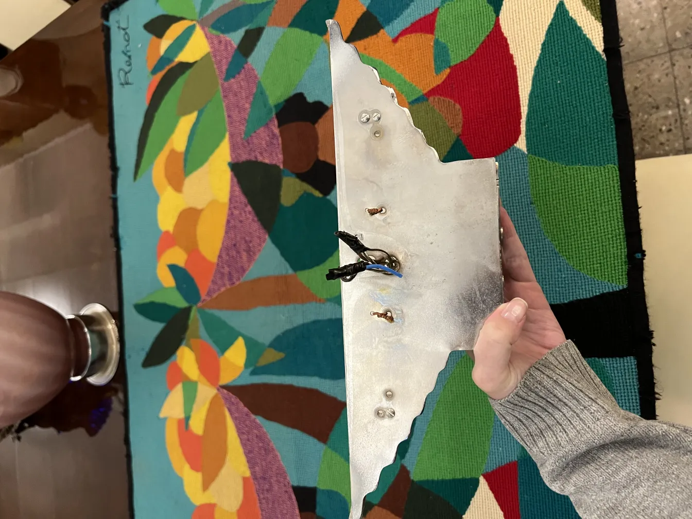 Coppia di applique antiche con design unico in un ambiente colorato.