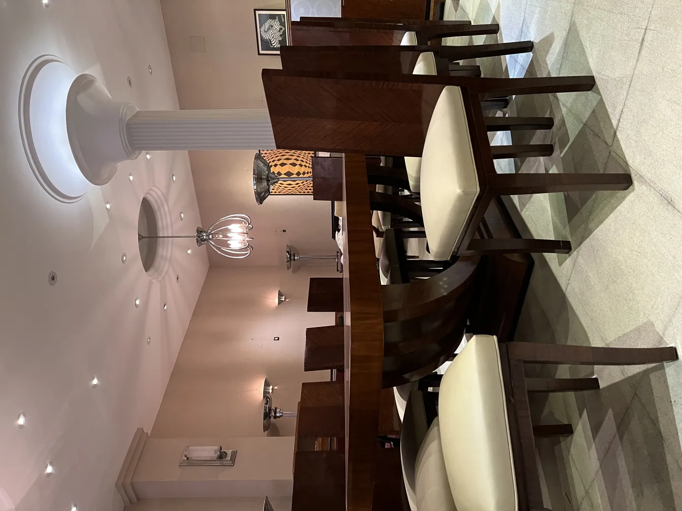 Par de apliques antiguos en un entorno elegante con sillas de madera.