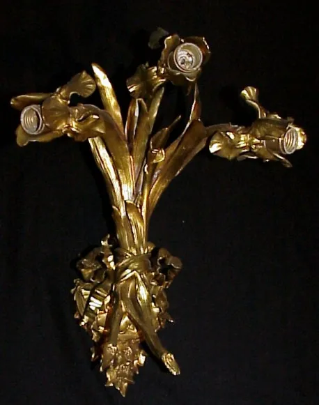 Antiguos apliques con diseño de rosas doradas sobre fondo negro.