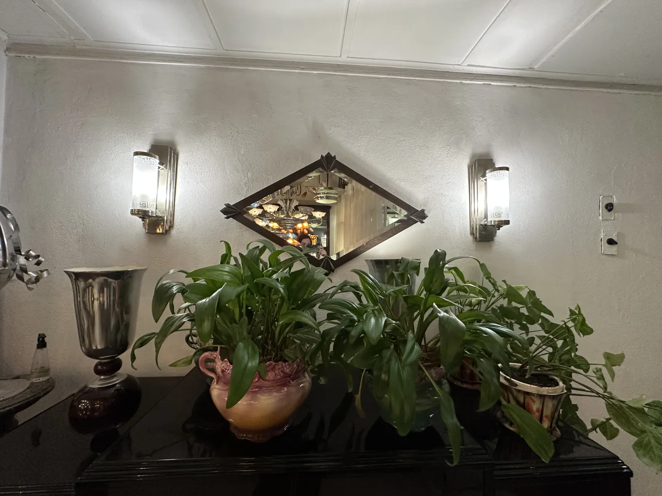 Parete con applique antiche e decorative accanto a piante