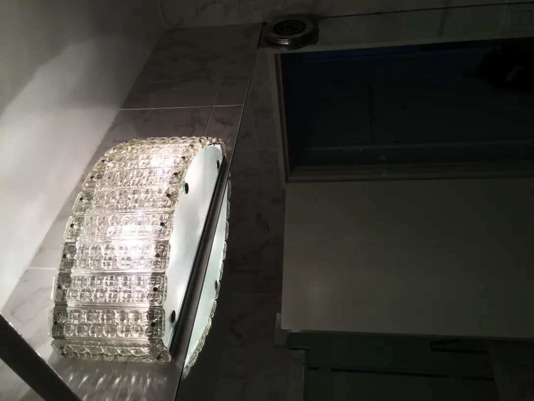 Antique pair of glass sconces in lit bathroom