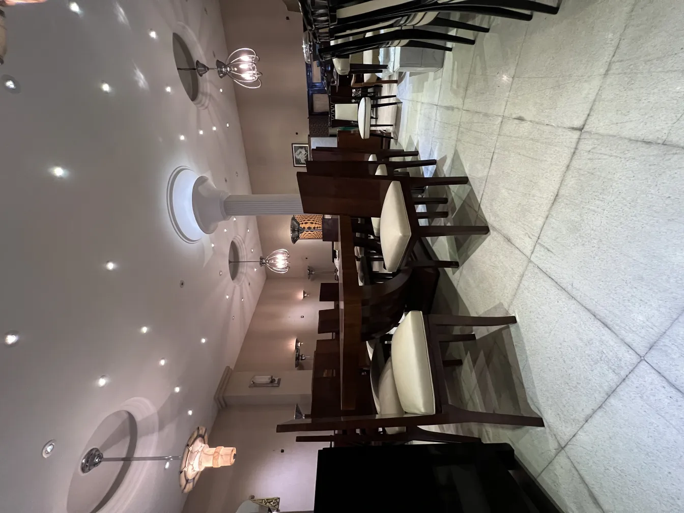 Antique sconces above tables and chairs in a dining area.