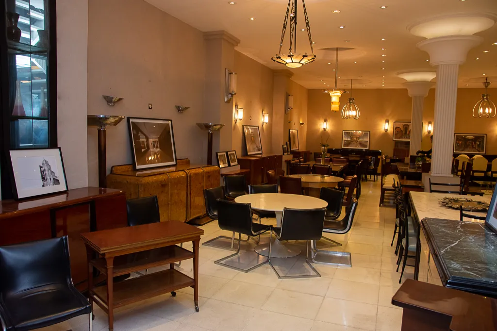 Paire d'appliques anciennes dans un environnement contemporain avec des chaises et des tables.