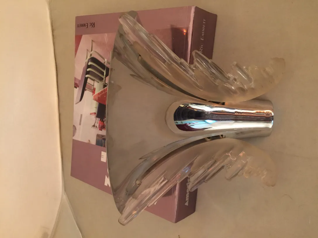 Par de apliques antiguos con un diseño único, suaves curvas y detalles brillantes, ideal para ambientar espacios.