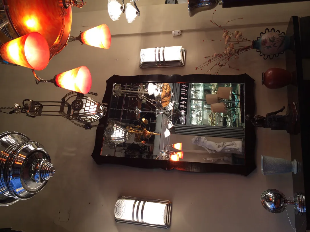 Pair of antique sconces with warm light, reflected in a mirror.