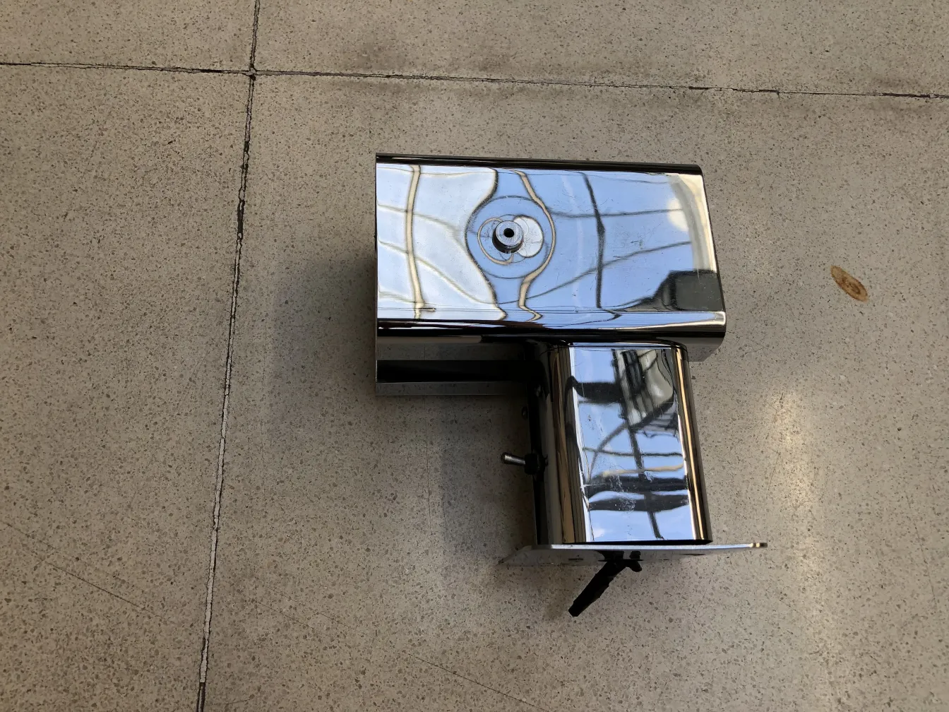 Antiker Metall-Wandleuchter mit glänzender Oberfläche auf hellem Hintergrund.