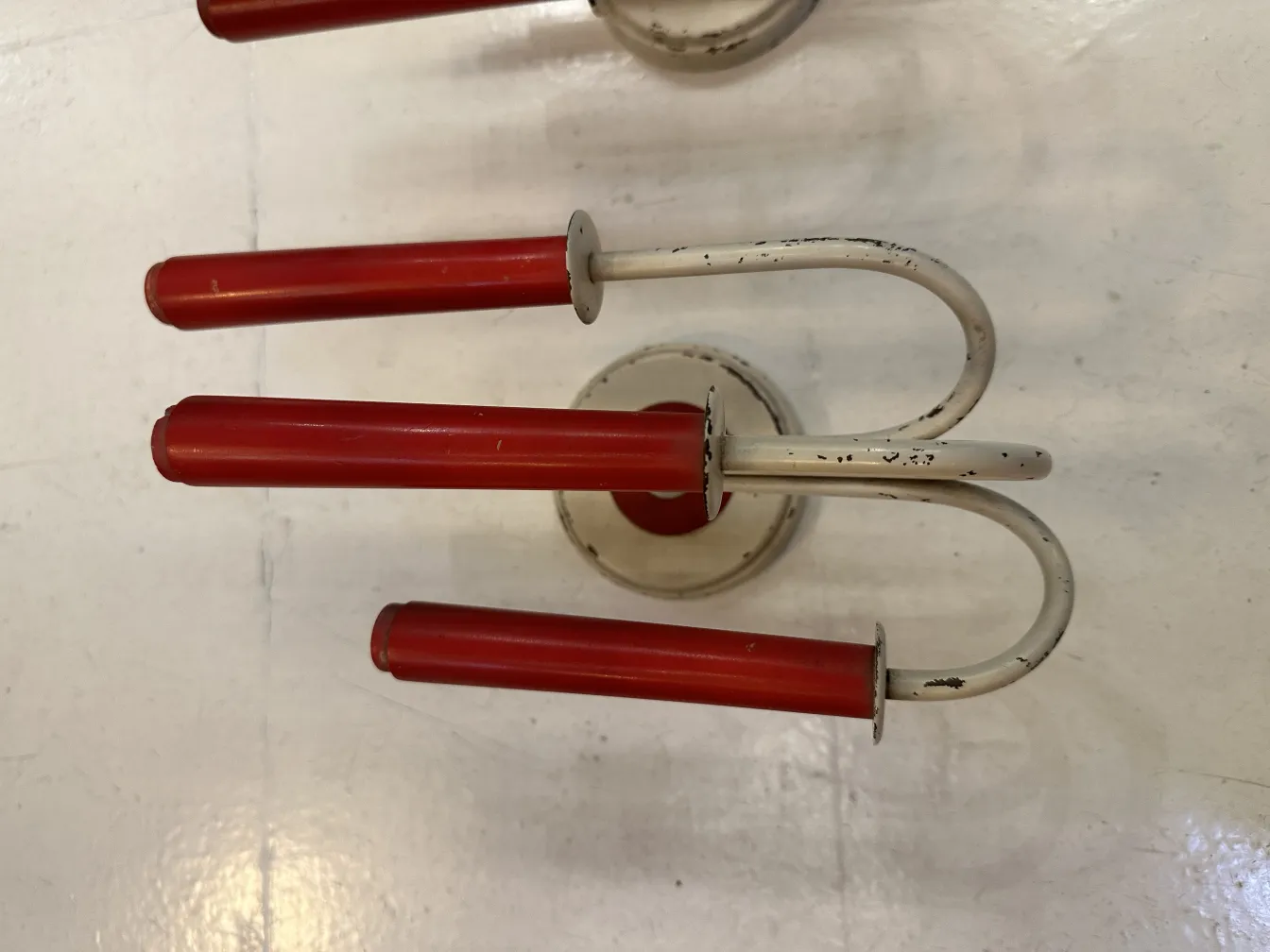 paire d'appliques anciennes aux finitions rouges et formes stylisées dans un cadre clair