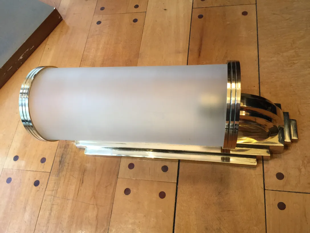 Par de luminárias de parede antigas com design elegante e detalhes impressionantes em um ambiente de madeira.