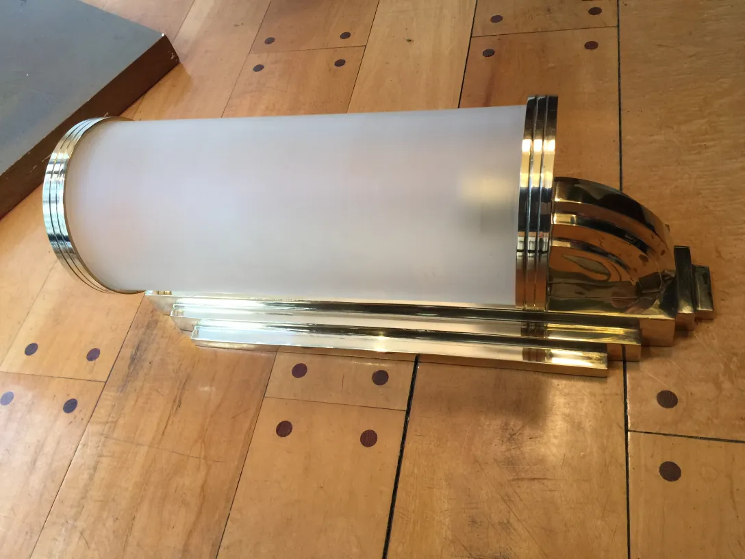 Antique pair of sconces with elegant classic design, adding light to a wooden space.